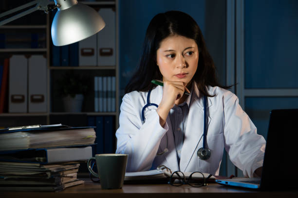 istock doctor over working online with a laptop 823502100