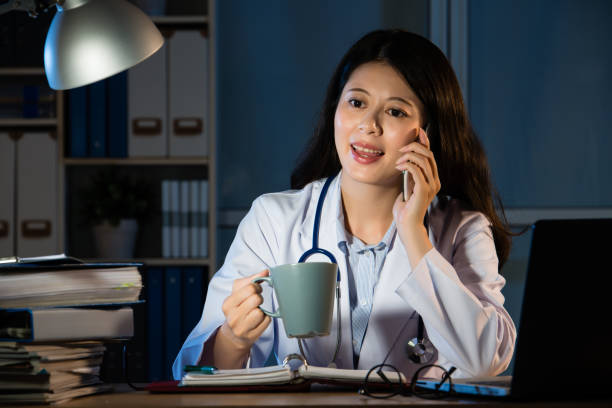 female doctor drinking coffee and making call - healthcare and medicine nurse doctor general practitioner imagens e fotografias de stock