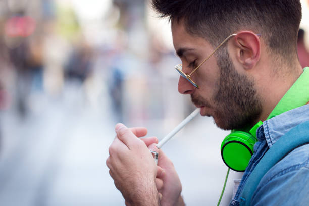 istock Man is lighting up a cigarette outdoors. 823514156