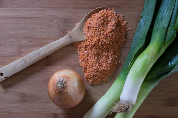 Red Lentils on Wooden Spoon with Leeks and Sweet Onion stock photo