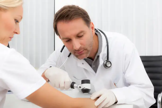 doctor checking the skin of a blonde woman.