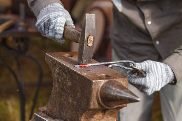 istock Blacksmith working on metal on anvil at forge high speed detail shot 823525160