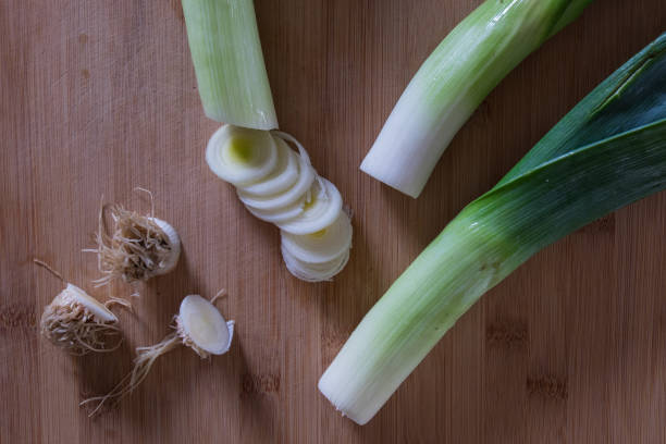 Three leeks about to be chopped on cutting board stock photo