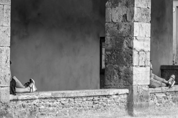 Bagno Vignoni, Italy - July 23, 2017: Tourists relax in the historic center of the beautiful village of Bagno Vignoni in Tuscany