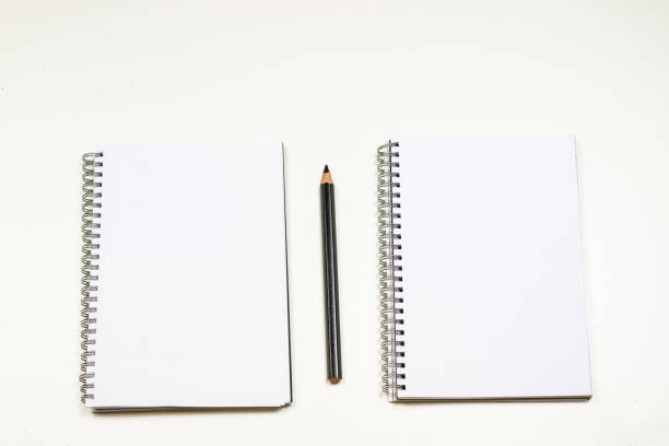 Sketchbook and crayons on a white table. White table and white background