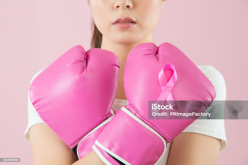 Chinese girl wear boxing gloves crossed arms Breast Cancer Stock Photo