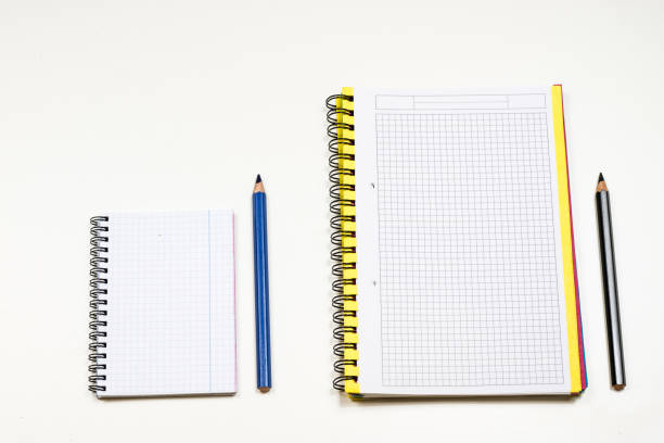 Sketchbook and crayons on a white table. White table and white background