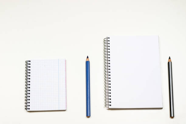 istock Sketchbook and crayons on a white table. White table and white background 823542376