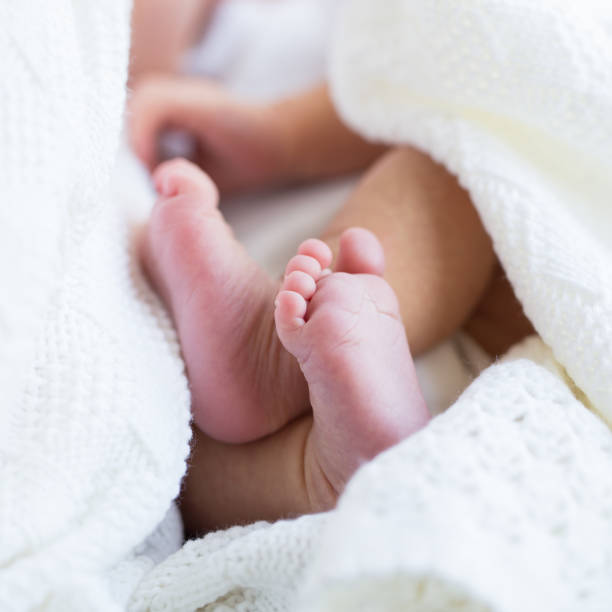 istock Baby legs in mother hands 823548510