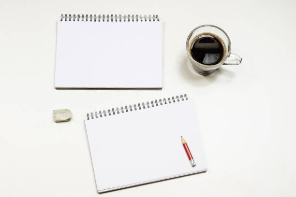 Coffee and sketchbook for drawings. White table. Isolated background. White background.
