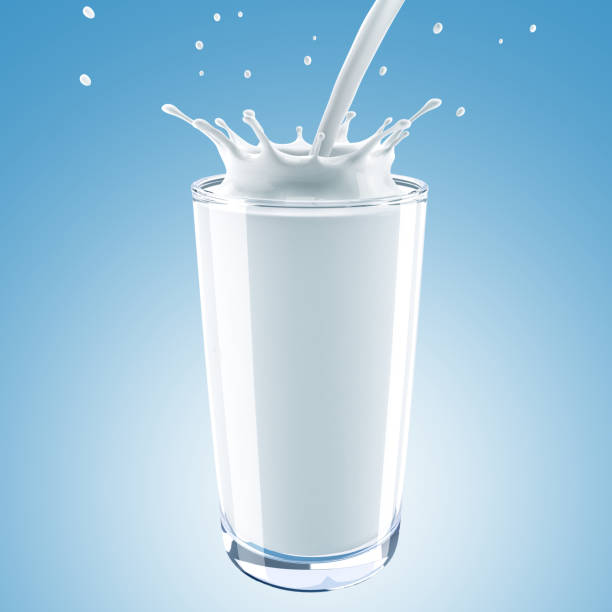 istock Milk is poured into a glass on a blue background 823581836