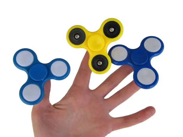 Photo of Hand holding popular fidget toy spinner.