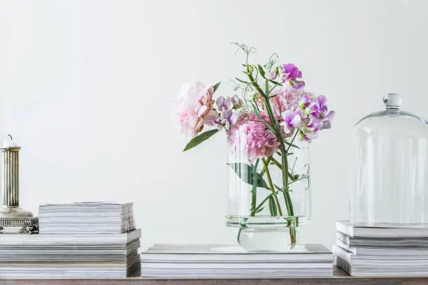 pink pastel flowers on a table with magazines