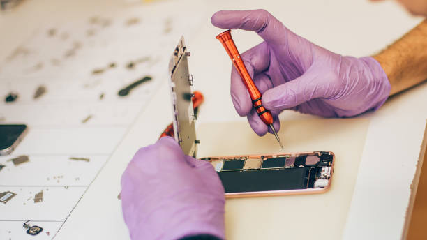 istock Technician repair faulty mobile phone in electronic smartphone technology service 823595232