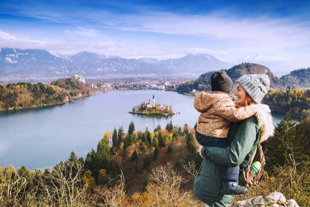 madre con hijo busca en el lago de bled. otoño o invierno en eslovenia, europa. - cordillera karavanke fotografías e imágenes de stock