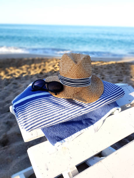 istock Summer composition with beach accessories hat, towel and sunglasses on the sandy beach 823619334