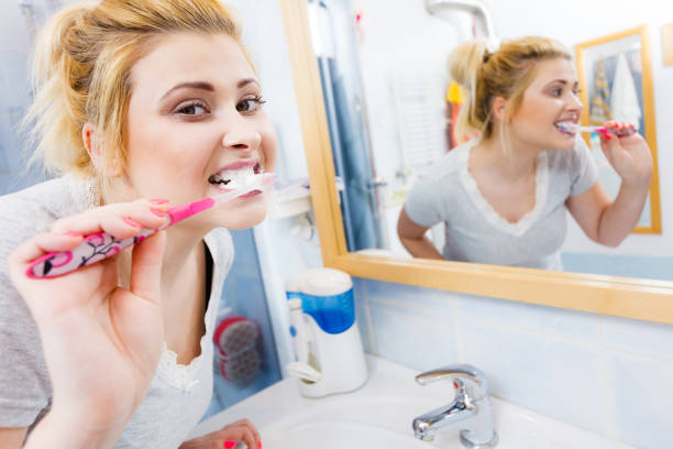 istock Woman brushing cleaning teeth in bathroom 823619594