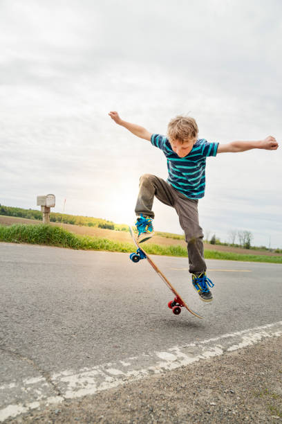 istock Young boy practicing skateboard in rural street. 823620140