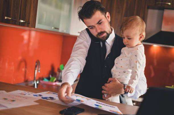 istock Father multi-tasking and holding baby boy 823620418