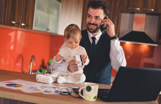 istock Father talking on the phone and holding baby boy 823623260
