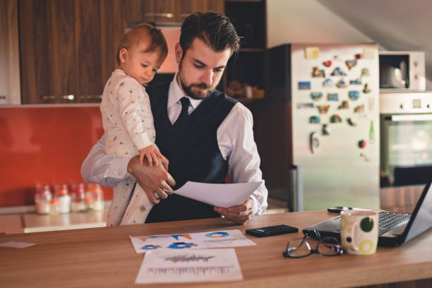 istock Young father working and holding his baby boy 823623388