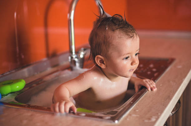istock Adorable Baby Boy taking a bath in Sink 823628302