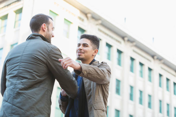istock Young Hispanic man shaking hands with friend in city 823631554
