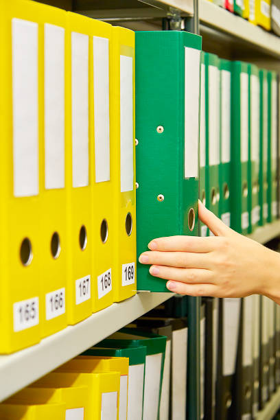 istock Yellow and green file folders in archive and human hand 823631626