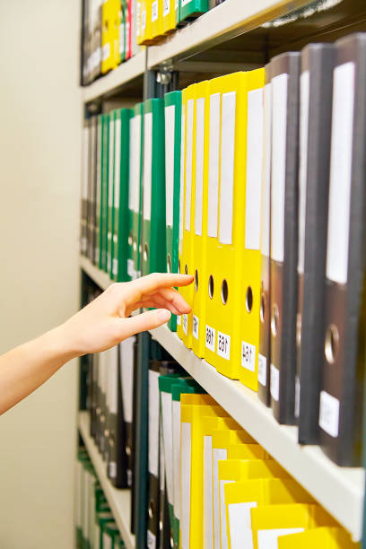 istock Yellow and green file folders in archive and human hand 823631628