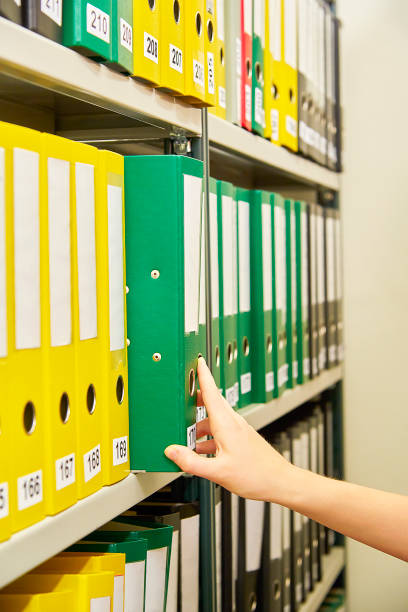 黄色と緑のファイル フォルダー アーカイブと人間の手で - ring binder file green document ストックフォトと画像