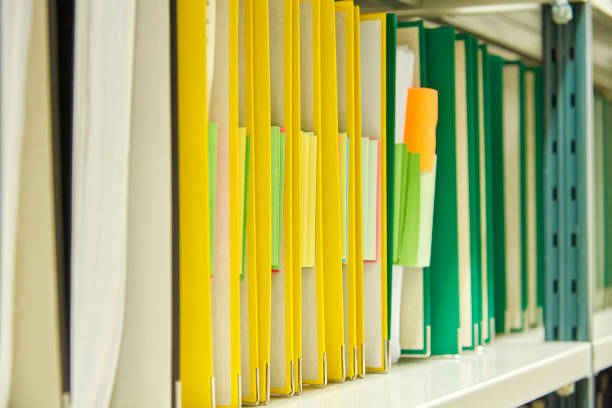 istock Yellow and green file folders in archive and human hand 823631694