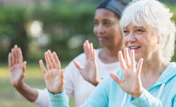 istock Two mature women in the park doing tai chi exercises 823634528