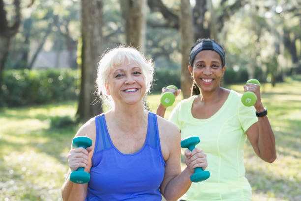 istock Two senior women exercising in park with hand weights 823634748