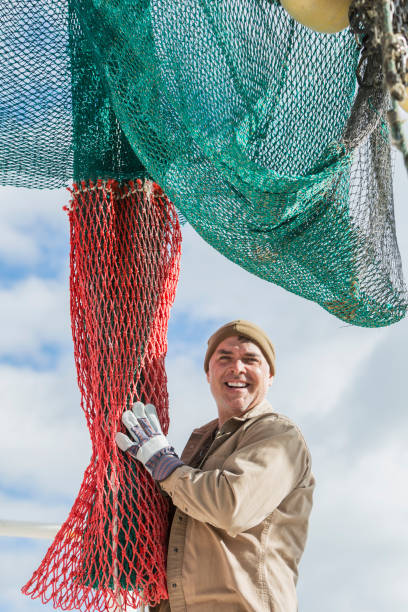 istock Man working on commercial fishing boat, preparing net 823637236