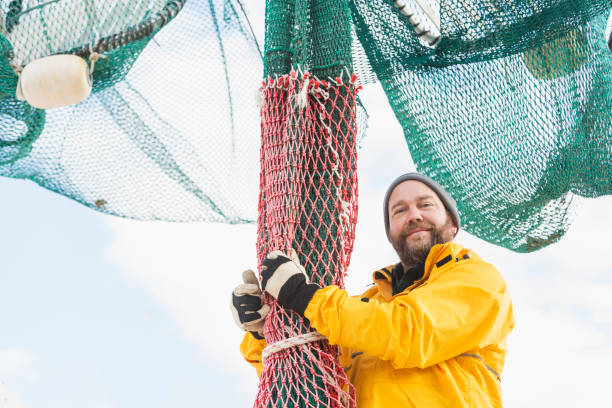 istock Man working on commercial fishing boat, preparing net 823637260