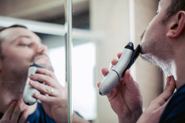 istock Attractive Man shaving with electric razor 823646842
