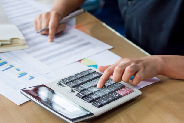 istock woman hand using calculator and writing make note with calculate 823647958