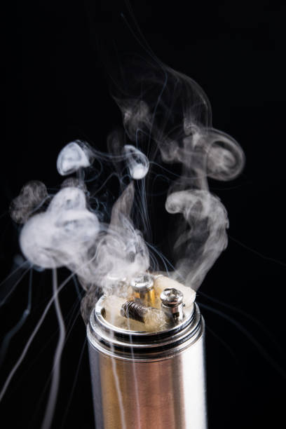 istock Checking the operation of an electronic cigarette with smoke on a black background 823648394