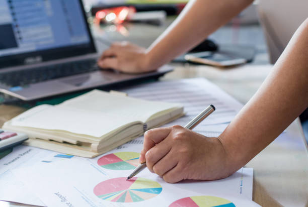 istock woman hand calculate cost and expenses and using laptop for search data result 823660786