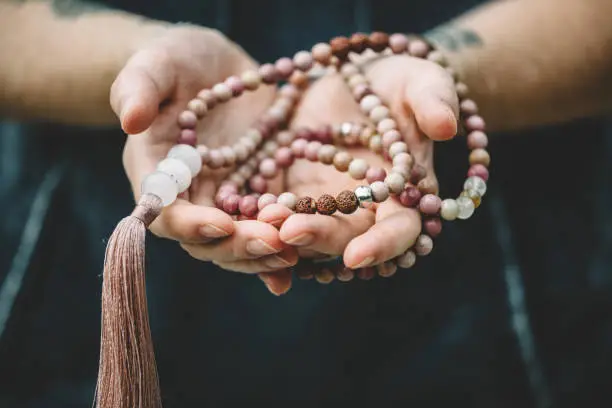 Hands holding mala prayer beads.