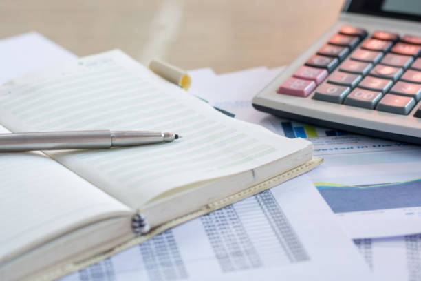 istock Close up pen on finance report and calculator on table office. 823664712