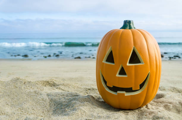 istock Halloween pumpkin background on the beach 823665700