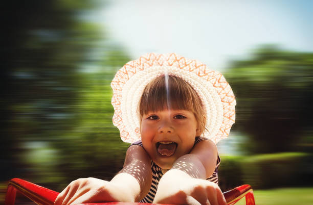 happy girl on a revolving carousel at the blurred movement in the background of green Park. baby fun on the Playground