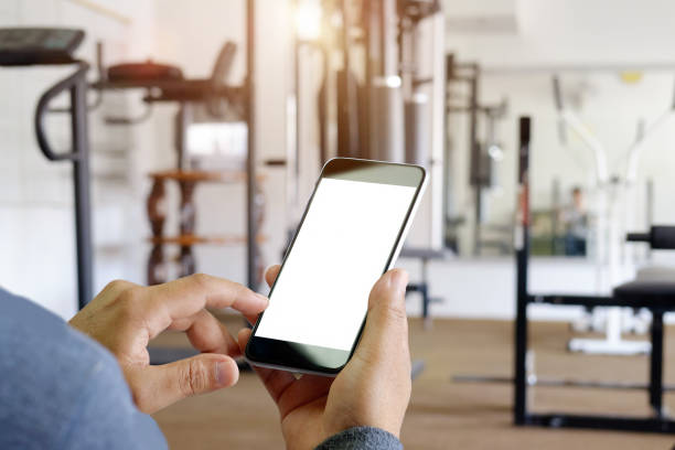 istock man hand holding smartphone device at gym background. 823671934