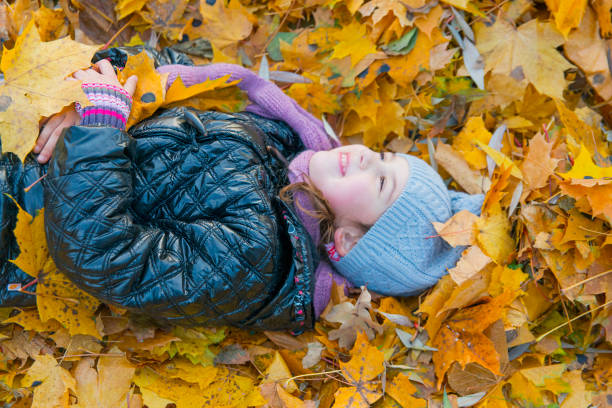 istock Children play in autumn Park.Falling leaves from trees. 823675950
