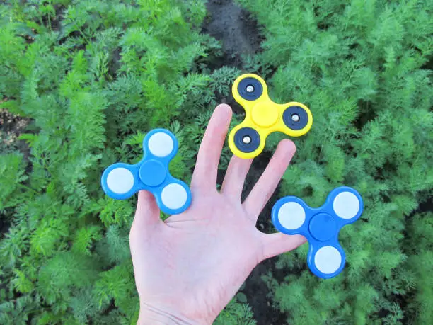 Photo of Fingers of a hand are held by three spinners.