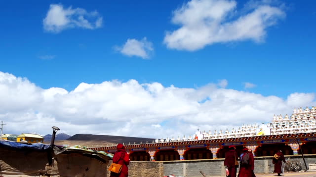 Tibetan buddhist monks and nuns walking at the pagodas in Yarchen Gar Monastery