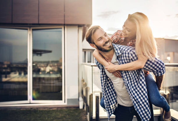 istock Young happy couple having fun while piggybacking on a terrace. 823700942