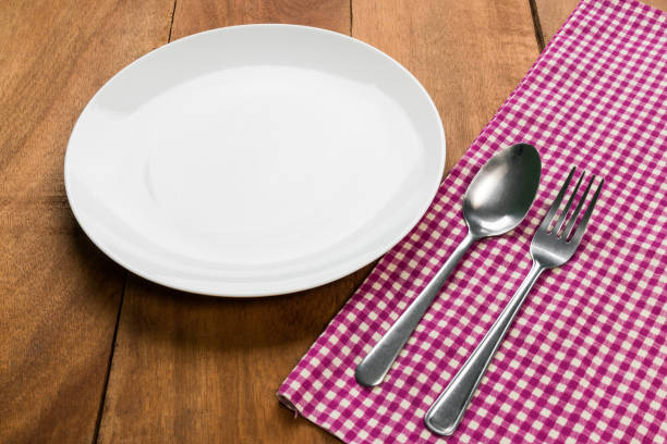 istock spoon and fork on tablecloth with white plate on wooden table 823708182