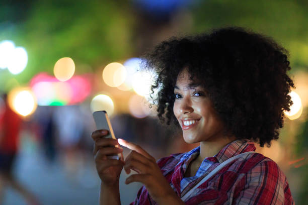 istock Smiling tourist using smart phone at night on street 823708644